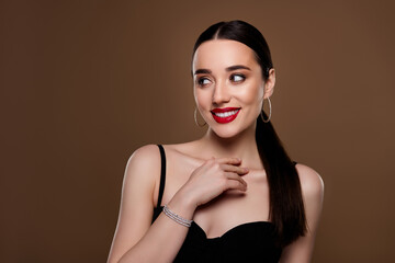 Photo of tempting seductive woman wear black dress touch chest look emtpy space isolated brown...