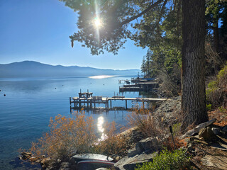 a gorgeous winter landscape at Lake Tahoe with blue lake water, lush green trees and plants,...