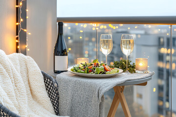 Romantisches Abendessen auf modernem Balkon mit Salat und Sekt