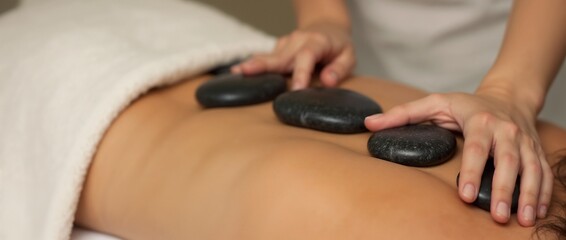 Experience relaxation and wellness through therapeutic hot stone massage in a tranquil spa environment, ideal for relieving stress and promoting balance.

