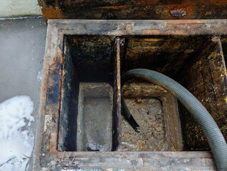 Waste pumping from the sewer. Mud and sludge removing by pumping hose