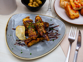 Delicious Spanish dish with grilled eggplant, cane sugar and green onions