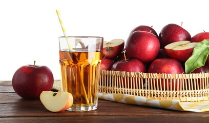 Tasty apple juice in glass and fresh fruits on wooden table against white background