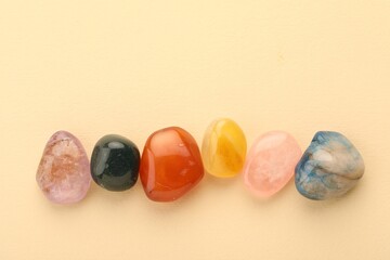 Beautiful natural gemstones on beige background, flat lay. Space for text
