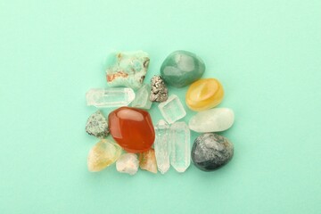 Beautiful natural gemstones on turquoise background, flat lay