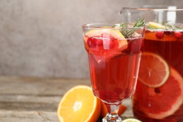 Aromatic punch drink in glass and jug on table, closeup. Space for text