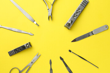 Frame of pedicure tools on yellow background, flat lay. Space for text