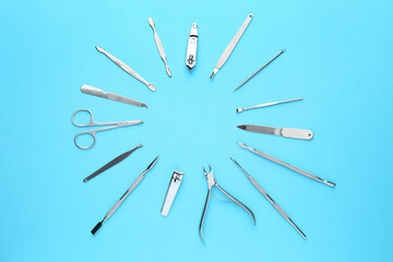 Set of pedicure tools on light blue background, flat lay