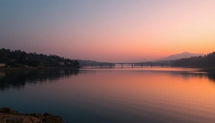 Fototapeta premium view of a bridge over a river at sunset