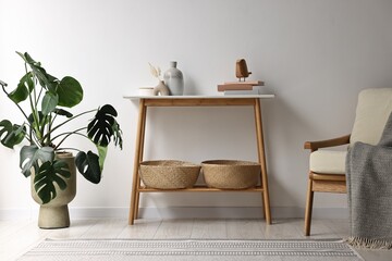 Stylish room interior with console table near white wall