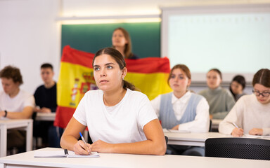 Young female student attentively listening to a lecture in a classroom