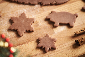 Star and pig shapes cut out from raw pastry dough - preparation of gingerbread Christmas cookies