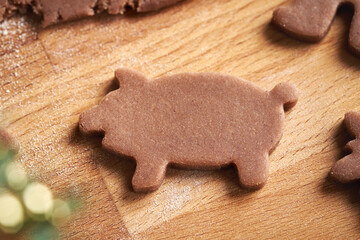 Pig shape cut out from raw pastry dough - preparation of homemade gingerbread Christmas cookies