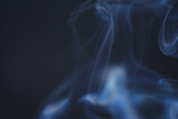 Close up of incense smoke as background. Smoke is the gaseous products of burning materials especially of organic origin made visible by the presence of small particles of carbon