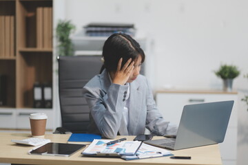 Asian women are stressed while working on laptop, Tired asian businesswoman with headache at...