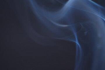 Close up of incense smoke as background. Smoke is the gaseous products of burning materials especially of organic origin made visible by the presence of small particles of carbon