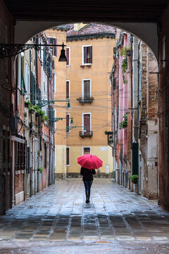 Fototapeta Woman with red umbrella walking in the streets of Venice, Italy