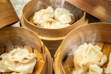 Assorted chinese dim sum dumpling on bamboo wooden basket bowl on wooden table