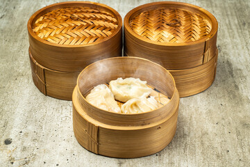Chinese dim sum dumpling on bamboo wooden basket bowl on wooden table