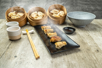 Fried chinese dim sum dumpling, gyoza, jiaozi or mandu in the plate with chopsticks and soy sauce on the table. Food for breakfast, lunch or dinner