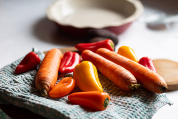 Fresh peppers lie on a wooden cutting board.