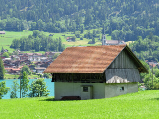 Obraz premium Traditional rural architecture and family livestock farms on the shores of Lake Lungern - Canton of Obwald, Switzerland (Traditionelle Architektur am Ufer des Lungernsees - Schweiz)