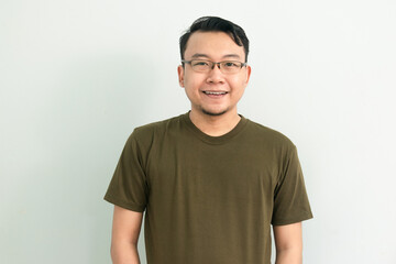 Confident asian man with green tshirt smile at camera. Isolated portrait.