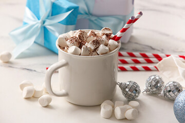 Cup of hot cocoa with marshmallows, Christmas balls and gift boxes on white background