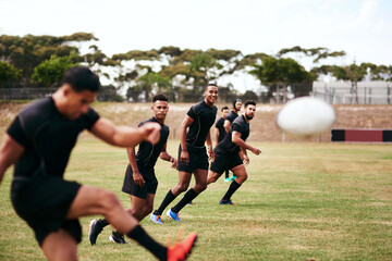 Sports, kick and team of rugby players at match, training or competition with opponent. Outdoor fitness and men athletes playing game for practice, workout or exercise of skill on field at stadium