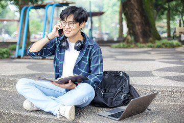 Student Working on Laptop While Talking on Phone Outdoors