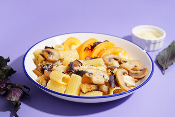 Plate with delicious Italian pasta salad on violet background