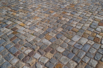 Background of bricks road. Background with bricks road. Stone cladding pavement. Brick surface background. Rough brick road. Stone pavement texture.