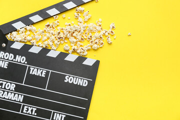 Movie clapper with popcorn on yellow background