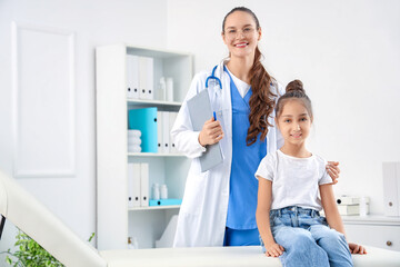 Fototapeta premium Female pediatrician with little girl in clinic