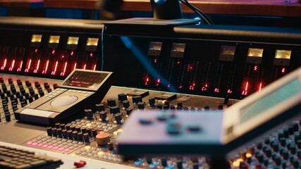 Empty professional studio being equipped with modern technical equipment, control room with sliders, faders and knobs used in mixing and processing sounds. Track recording concept.