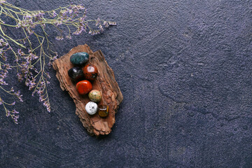 Set of chakra stones and flowers on dark background