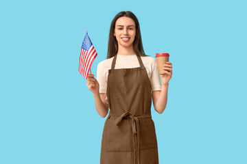 Young female barista with USA flag and cup of coffee on blue background