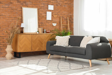 Interior of modern living room with sofa, commode and frames