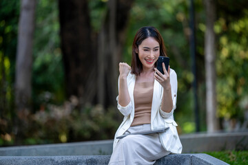 A woman is sitting on a bench with a cell phone in her hand