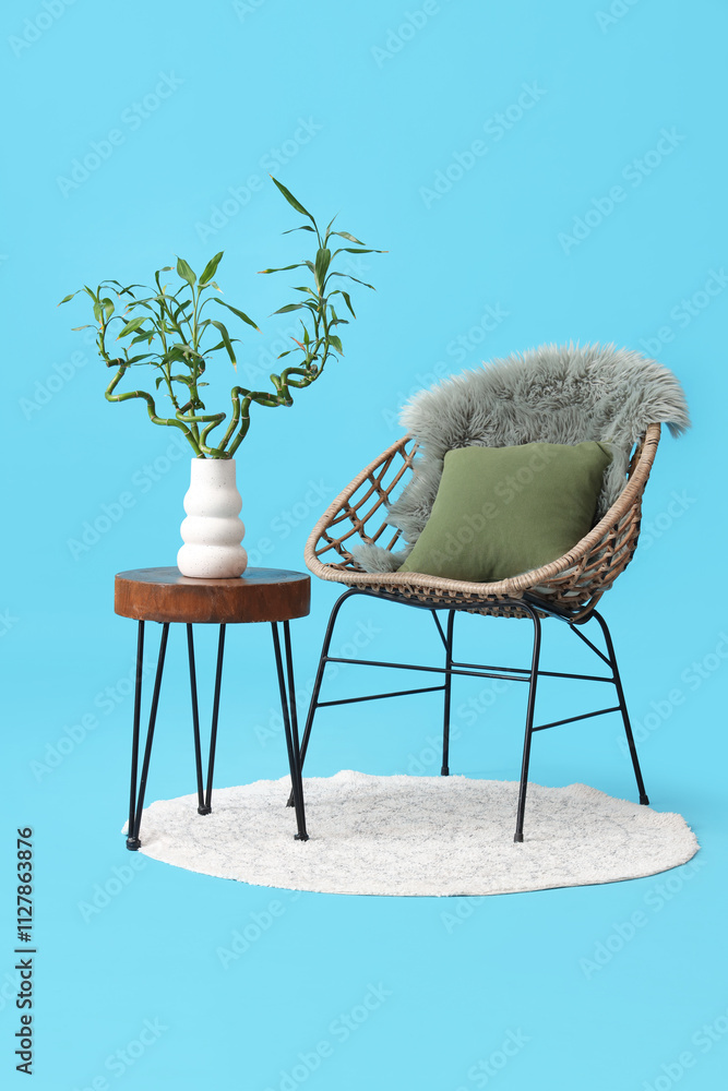 Canvas Prints Table with bamboo stems in vase, armchair and rug on blue background