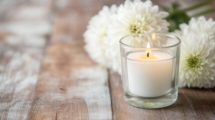 Obraz na płótnie Canvas A blank card is placed alongside lit candles and fresh white flowers, creating a serene and inviting atmosphere on a wooden table