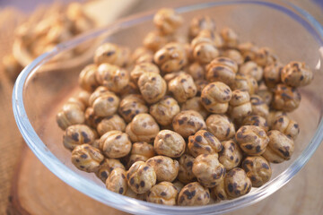Close-Up View of Roasted Chickpeas in a Glass Bowl on Wooden Table