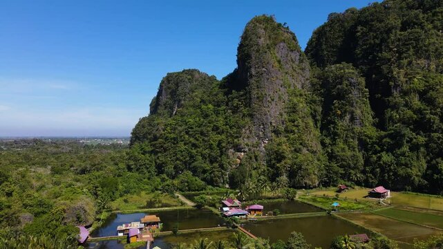 Rammang-Rammang Karst Village, Sulawesi, Indonesia - A Village Encircled by Towering Limestone Cliffs and Distinctive Karst Formations - Aerial Pullback Shot