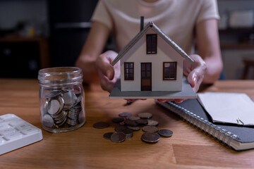 house model and money coins saving for concept saving money for buying a house, investment mortgage finance, and home loan refinance financial plan home loan.	