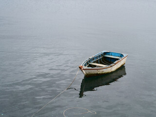 Small old wooden boat in calm water © LorenzoGaet
