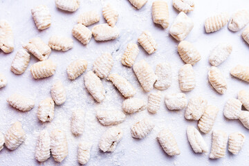 Top view of a counter full of gnocchi in preparation.