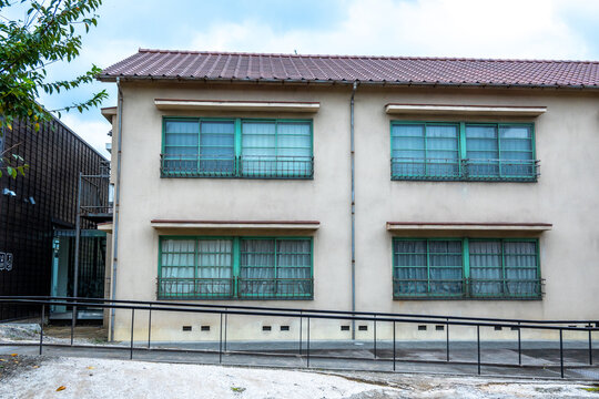 Traditional japanese apartment building with accessibility ramp and green windows
