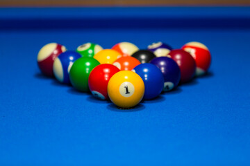 Billiards table and balls on a blue table.
