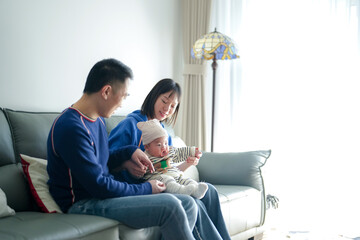 A 6-month-old boy spends time on a couch with his mother and father from a Chinese family on a cold winter day in an apartment building in the Pudong New Area of ​​Shanghai, China.