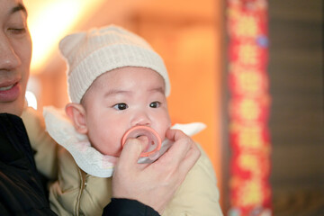 A six-month-old baby boy with a pacifier spends a cold winter day indoors with his father from a Chinese family in Pudong New Area, Shanghai, China.